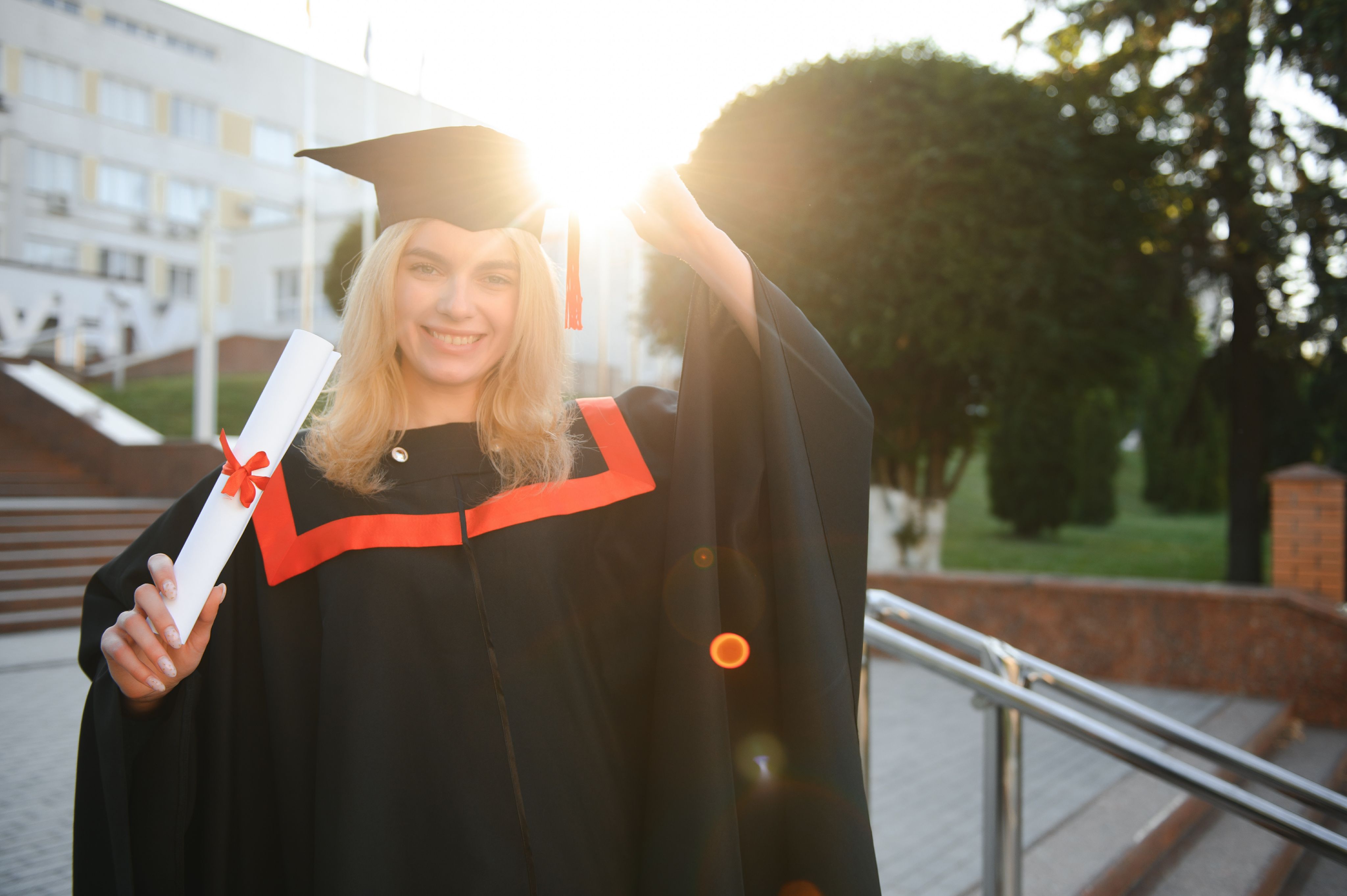 Happy woman with graduation cap holding diploma